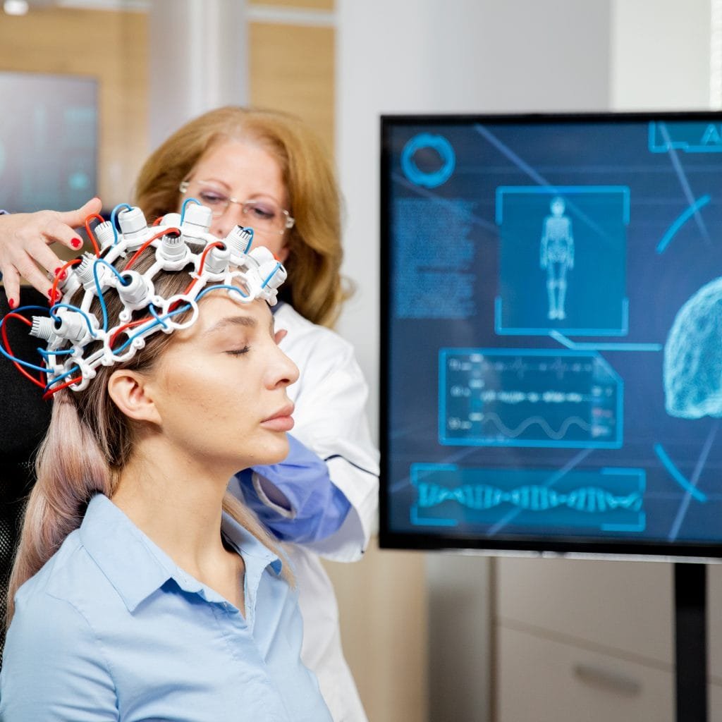 Doctor arranging scanning device on head of a female patient
